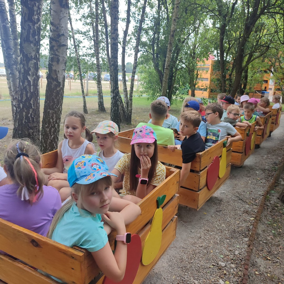 Sady Klemensa Grupa dzieci w małych owocowych wagonikach