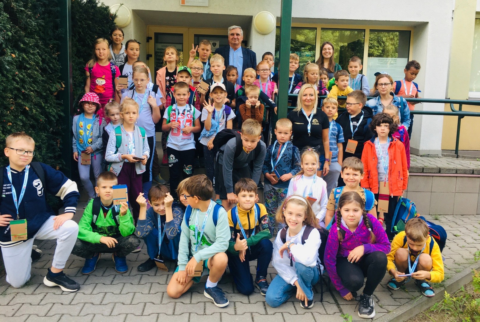 Wizyta Grupa dzieci przed budynkiem Gminy Ksawerów z wychowawcami i wójtem gminy